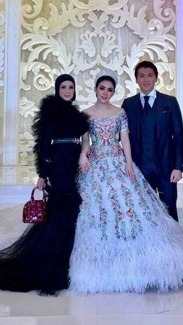 Mulan Jameela tampil cetar mengenakan dress bulu-bulu panjang saat hadiri pernikahan Syahrini.