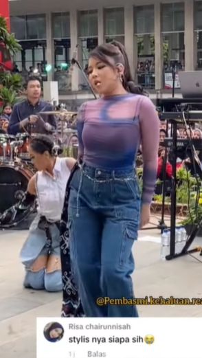 , Tiara Andini tampak mengenakan atasan ketat lengan panjang berwarna campuran ungu dan biru.