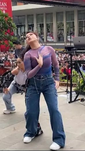 Ia memadukan busana tersebut dengan celana jeans yang diberi lilitan kain batik.