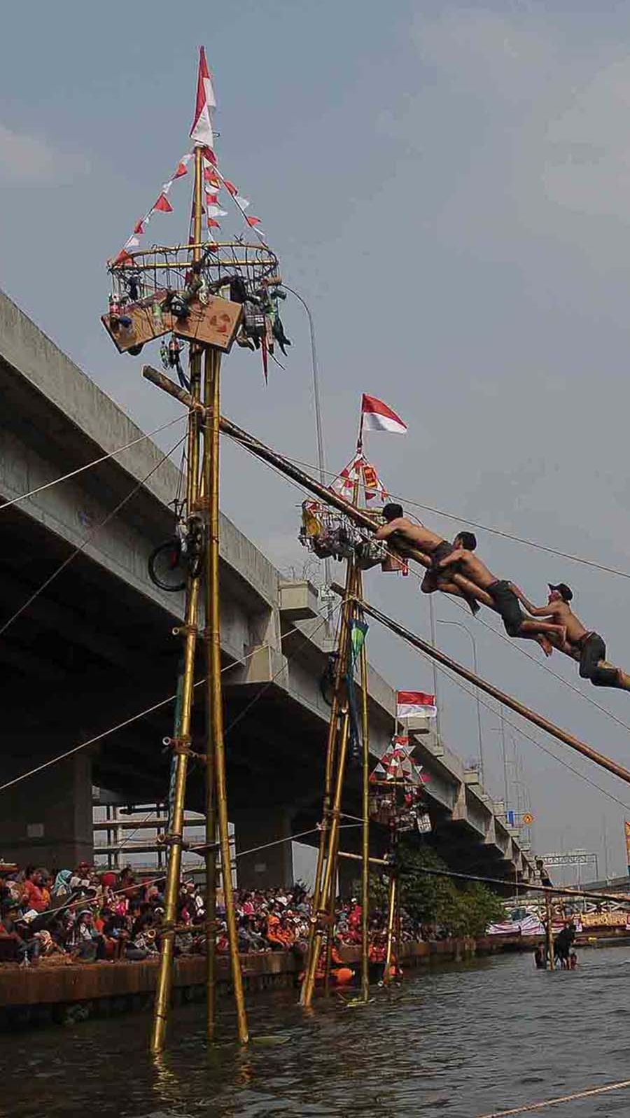 FOTO: Serunya Lomba Panjat Pinang Berhadiah Emas di Aliran Kalimalang, Gagal Jaga Keseimbangan Auto Nyebur