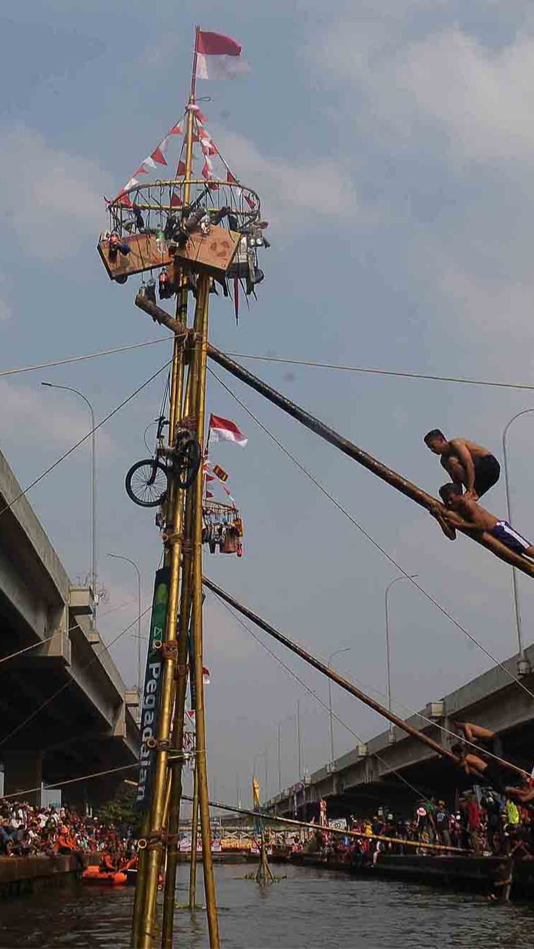 Uniknya, lomba panjat pinang ini tidak diadakan di atas tanah, melainkan di tengah-tengah aliran sungai.