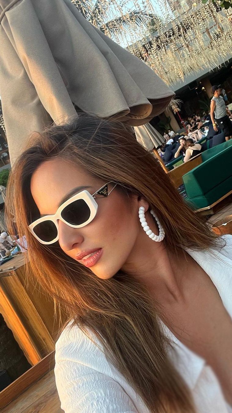 Outfit serba putih membuat kulit Nia terlihat sedikit tanned dan eksotis.
