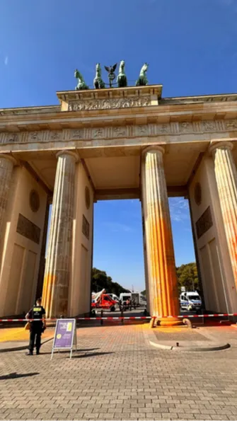The paint spread to Pariser Platz, the square around the Brandenburg Gate, with bright footprints visible along the street.