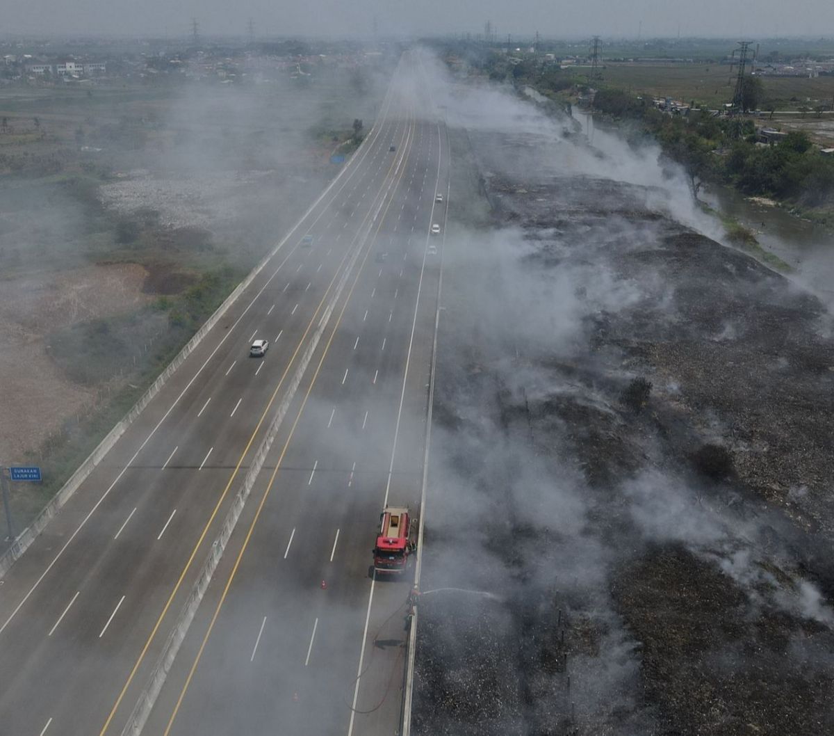 Saat ini petugas masih berjuang mengendalikan asap kebakaran yang masih mengepul dan menutupi jarak pandang pengguna jalan Tol Cibitung-Cilincing.