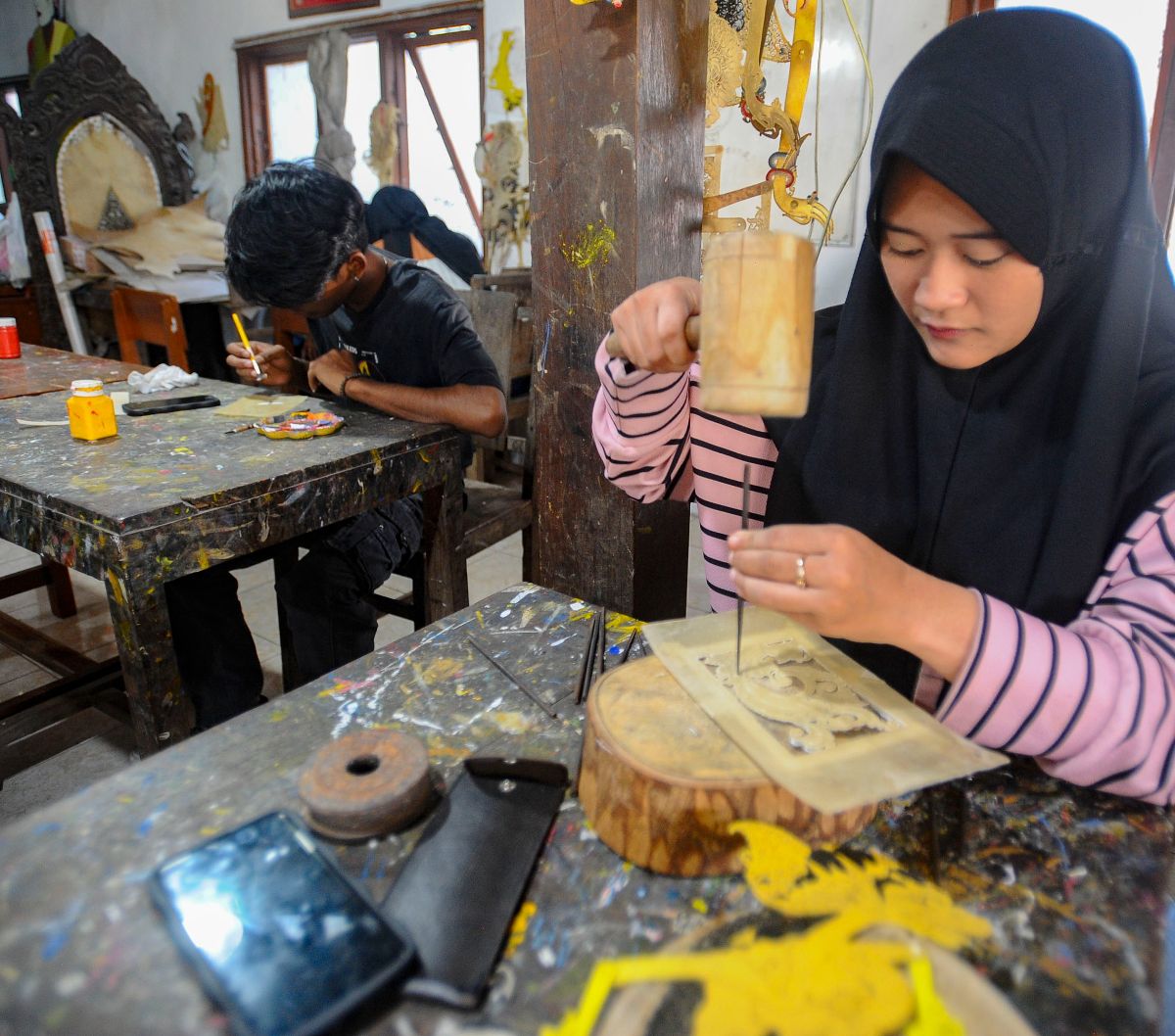 Mahasiswa Politeknik  ATK Yogyakarta belajar membuat wayang kulit di Griya Ukir Kulit (Wayang) Sagio di kawasan Bantul, Yogyakarta, Senin (04/09/2023).<br>