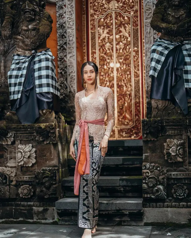 Anya terlihat anggun dalam balutan kebaya Bali berwarna cream yang dipadukan dengan bawahan kain songket berwarna hitam-emas.