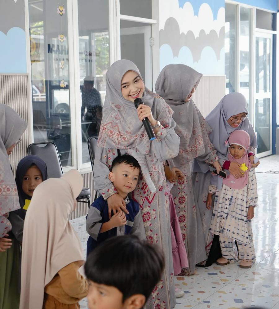 Ria Ricis tampil cantik dengan hijab dan gamis abu-abu berseragam dengan para pengajar lainnya.