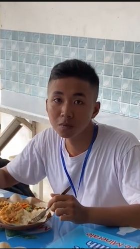 Siswa itu tampak sedang asyik menyantap makan siangnya