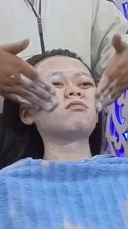 Wajahnya pun diberikan cairan berwarna putih yang langsung digosok merata ke seluruh bagian