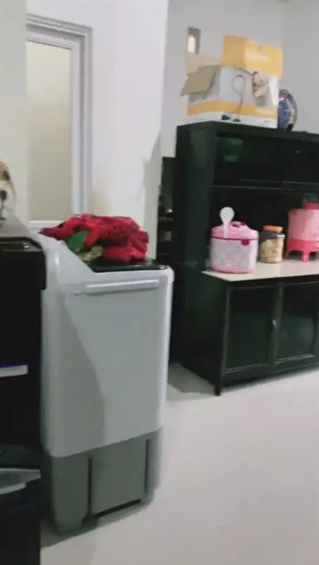 Untuk menutup area dapur dari bagian ruang tamu, ia memasangkan meja kabinet bernuansa hitam.