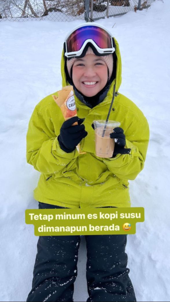 Lelah bermain ski, Natasha Rizky tetap minus es kopi susu yang jadi favoritnya meski cuacanya dingin.