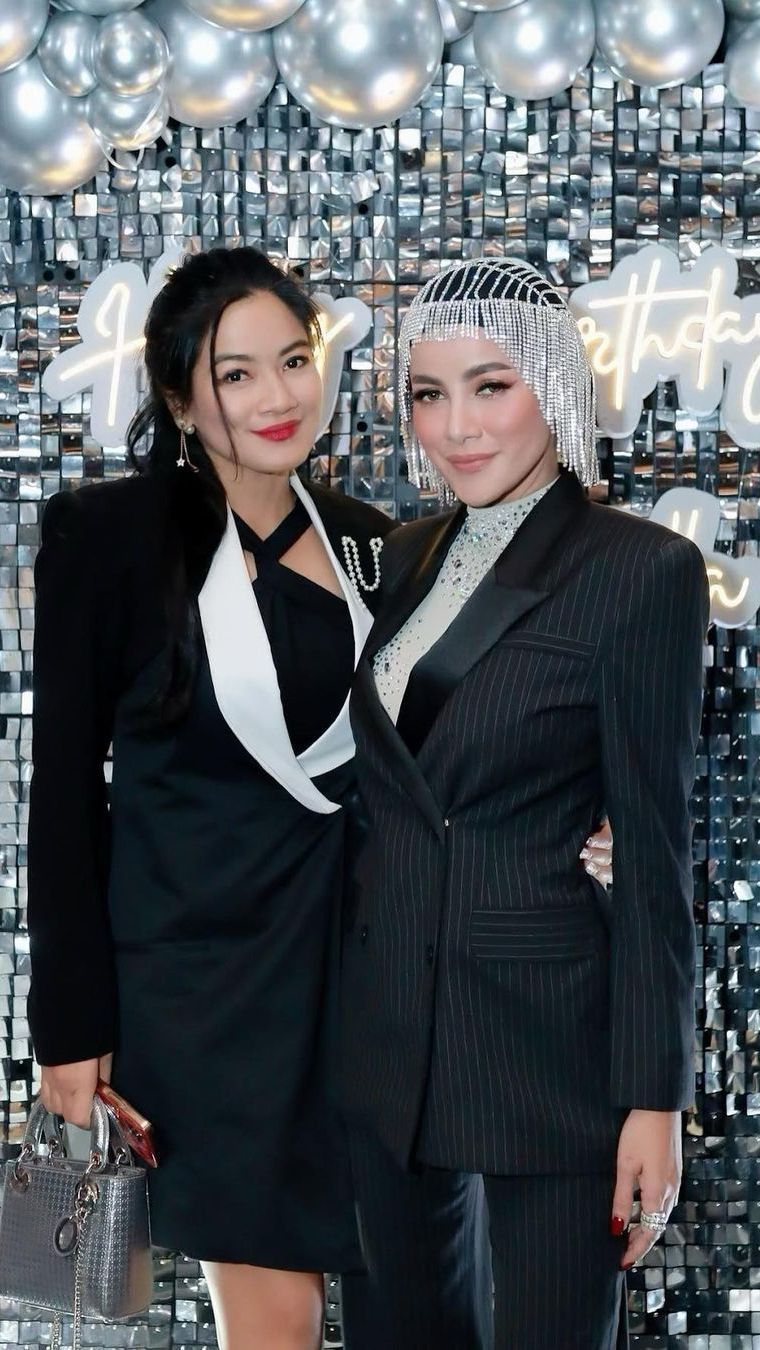 Titi Kamalkenakan blazer warna hitam dengan aksen abu-abu di bagian kerah.