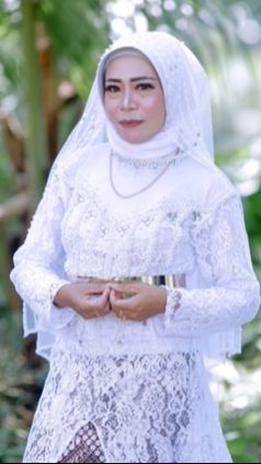 Dalam unggahan tersebut tampak sang wanita tampil dengan kebaya putih khas pengantin