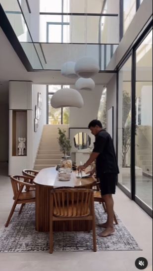 Ruang makan tak kalah estetik dengan meja kursi kayu dan lampu putih yang besar.
