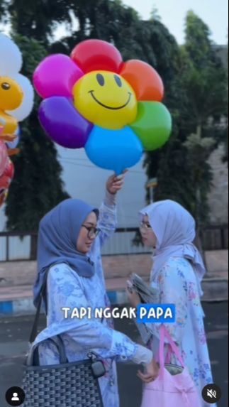 Saat memasukin area alun-alun ibu Vania berhenti untuk membelikan sang anak balon.