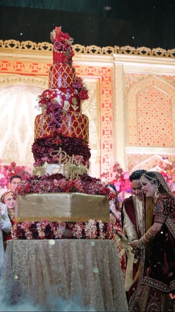 Kue yang megah bertema bollywood berwarna merah di pernikahan Putri Insari.