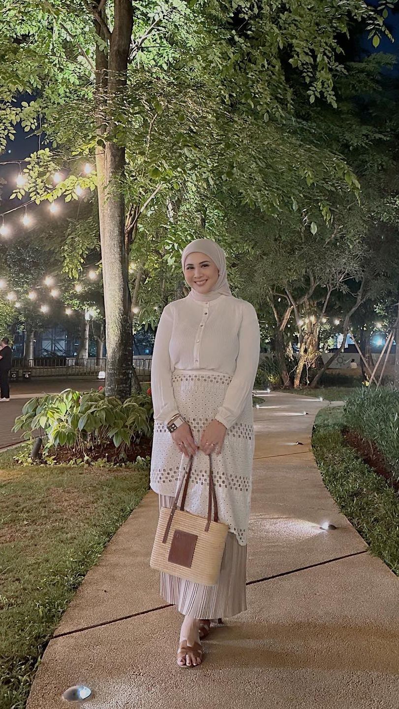 Keisha juga tampil cantik dengan atasan serba putih dan rok plisket nude yang kekinian