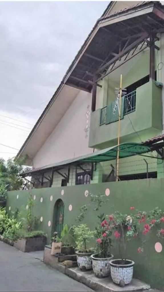Penampakan rumah tersebut dari samping. Terlihat bangunannya cukup besar dengan halaman yang luas