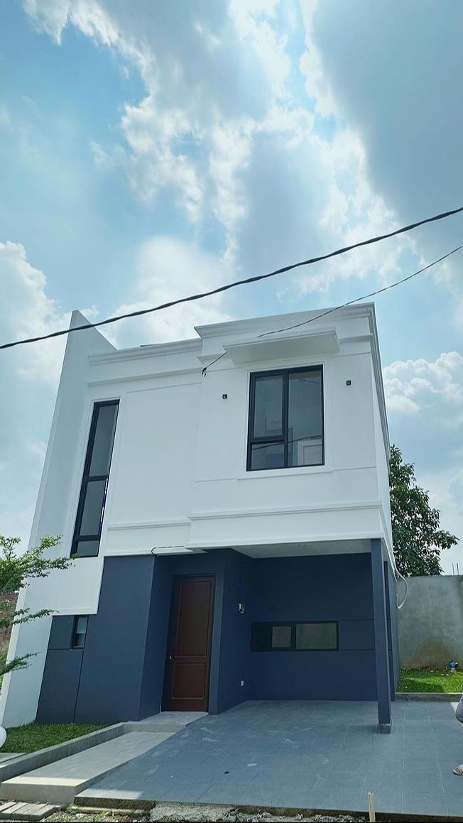 Rumah tersebut memiliki desain modern dengan perpaduan warna putih dan hitam.