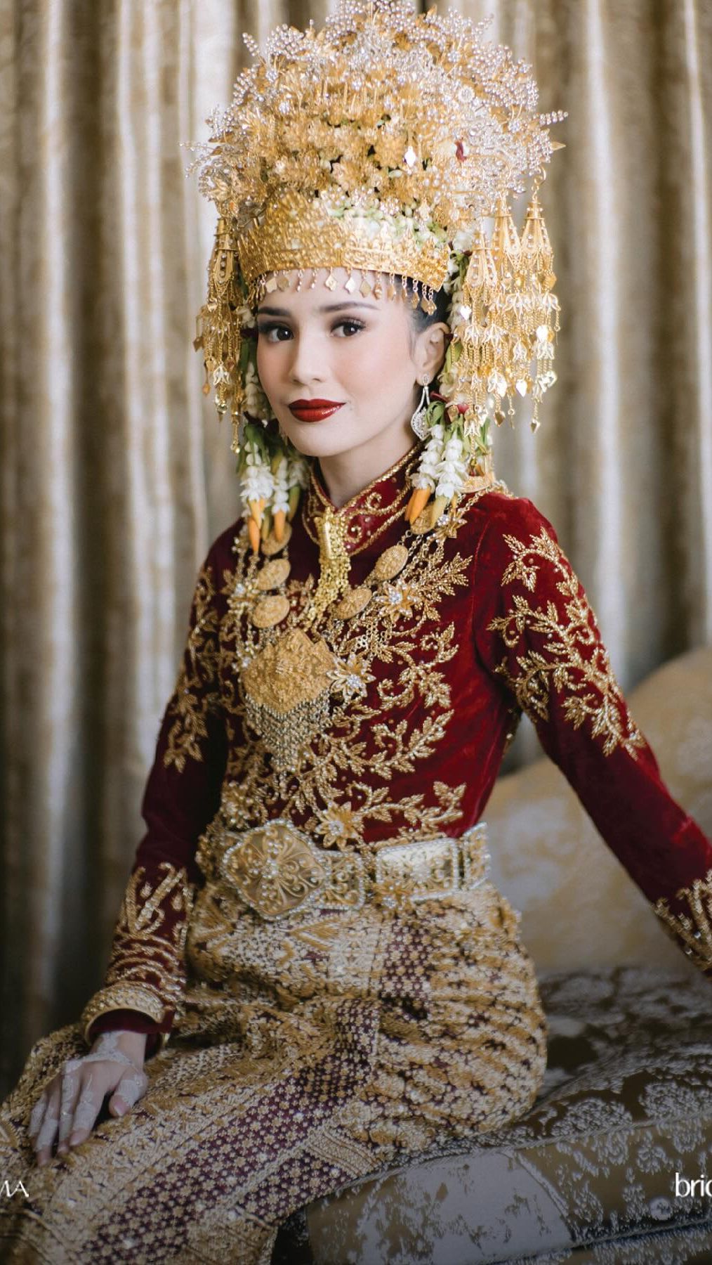 Beby tampil memesona dalam busana adat Aceh berwarna merah dengan aksen gold yang menyala.