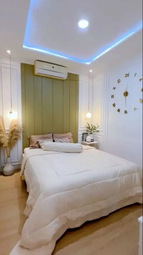 Kamar dibuat dengan super simpel dengan nuansa serba putih dan hiasan jam di temboknya.