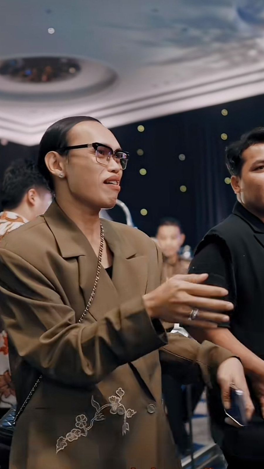 Wanda tampil maskulin mengenakan blazer cokelat serta celana panjang senada.