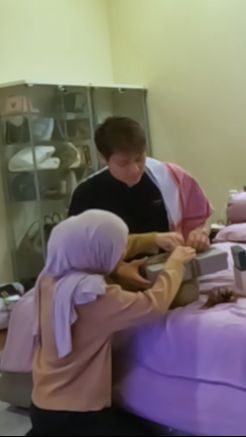 Kemudian ia kembali memberikan kado kedua yang disimpan dalam sebuah kotak persegi panjang.