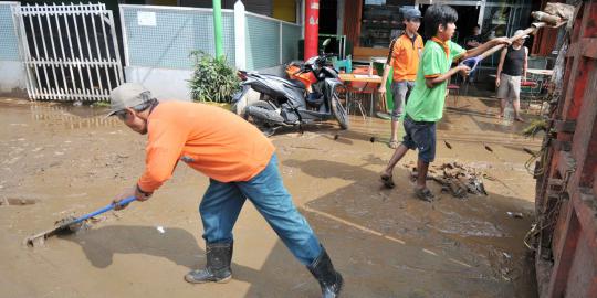 Bersih-bersih lumpur sisa banjir di Kampung Melayu