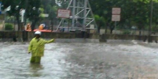 Tak kenal lelah, polisi atur lalu lintas di tengah banjir Jakarta