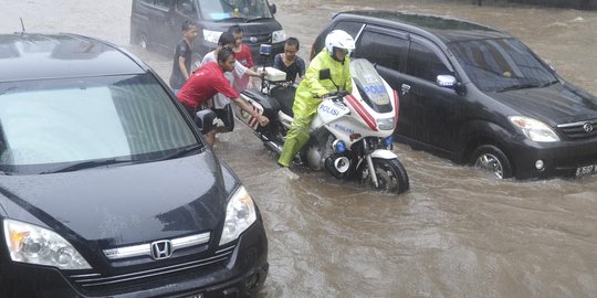 Terobos banjir polisi jatuh  dari motor  ditolong anak 