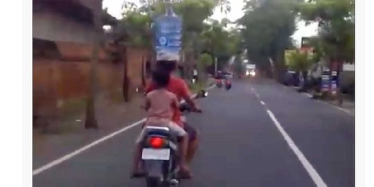 Wanita Bali ini mampu bawa galon air di kepala sambil naik motor