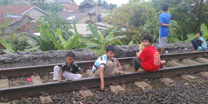 Para bocah ini tak takut tidur-tiduran di atas rel Stasiun Cibinong