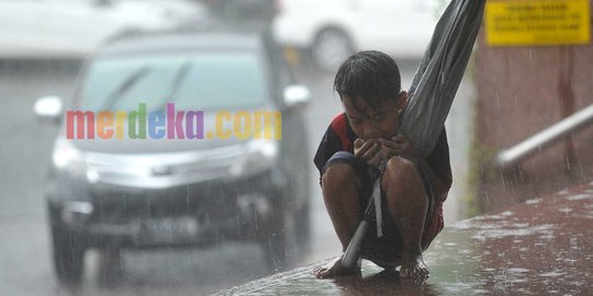 Potret haru sang bocah pengojek payung, kedinginan di tengah hujan