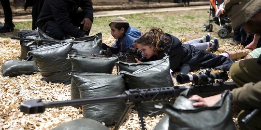 Aksi bocah Israel cicipi pegang senjata militer zionis