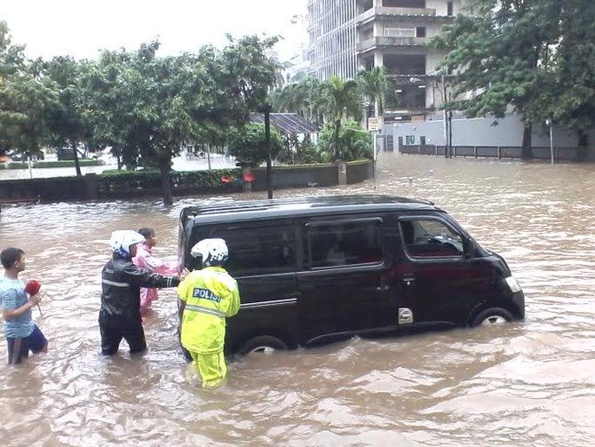 polisi dorong mobil mogok karena banjir