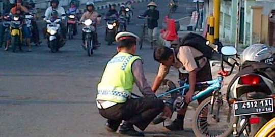 Foto polisi bantu anak sekolah pasang rantai bikin simpatik