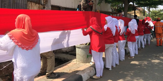 Di bawah terik matahari, ratusan ibu-ibu jahit bendera 500 meter