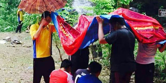 Salut, siswa non Muslim ini payungi temannya yang shalat saat hujan