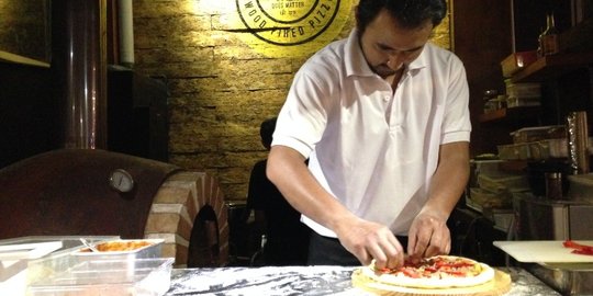 Menyantap pizza di bar dengan konsep dapur terbuka