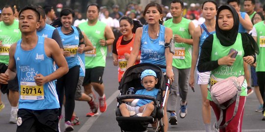 Ikut Jakarta Marathon, peserta ini berlari sambil dorong kereta bayi