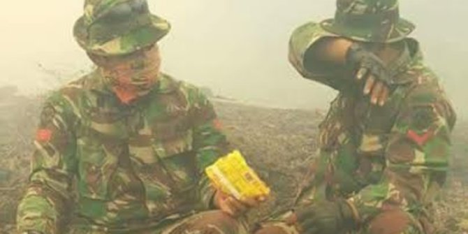 Kompaknya 2 anggota TNI berbagi mi instan di tengah kabut asap