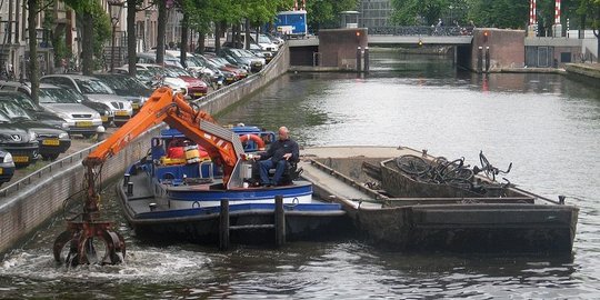 Memancing sepeda pada kanal-kanal di Amsterdam