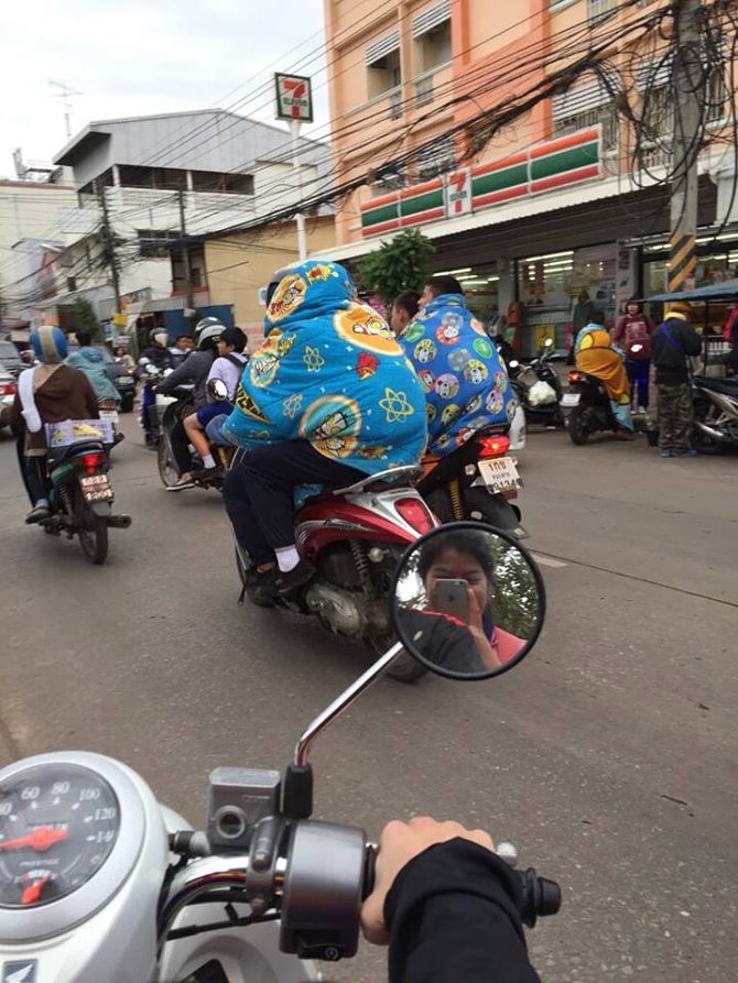 warga bangkok manfaatkan selimut untuk hadapi cuaca dingin