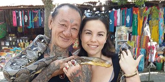 Pria penuh tato dan berkalung ular ini kerap diajak foto bule cantik