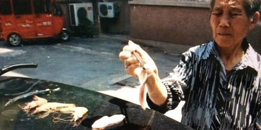 Panas menyengat, nenek di China panggang udang di atas mobil