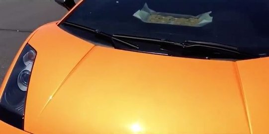 Cuaca panas, pria ini masak kue di dalam mobil lamborghini