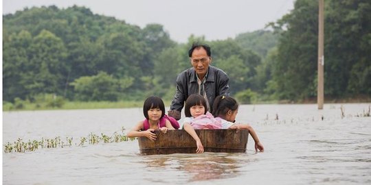 Meski banjir melanda, kakek ini terus antar cucunya bersekolah