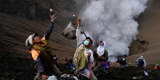 Nekatnya warga Tengger melempar sesaji di tengah erupsi Bromo