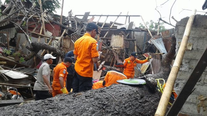 petugas evakuasi korban di lokasi pohon tumbang di sesetan denpasar