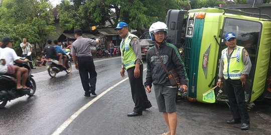 Kelebihan muatan, truk terbalik saat berbelok di tikungan tajam